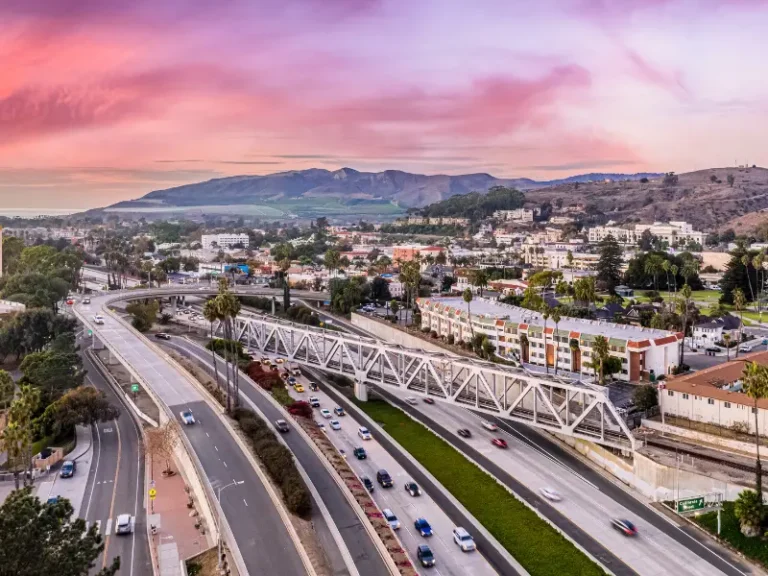 Aerial view of a highway overpass through a city at sunset.