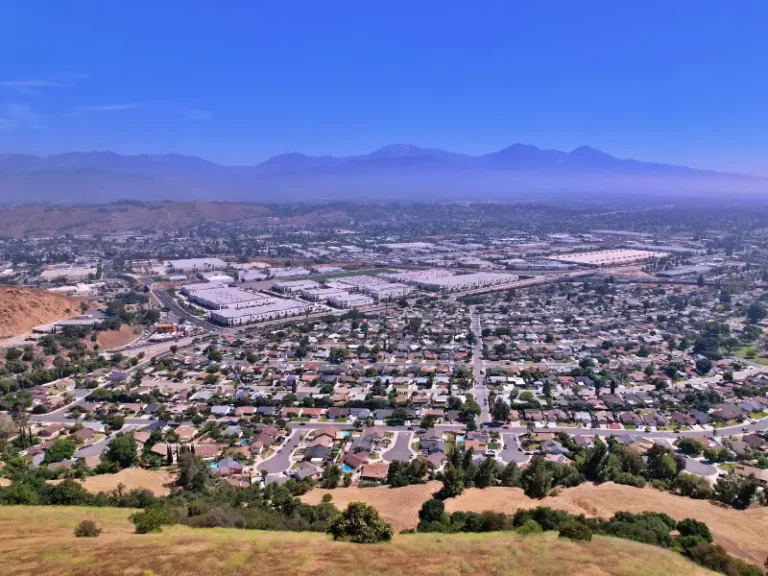 Aerial view of a suburban city with mountains in the distance.