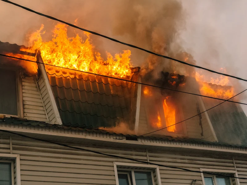 House roof engulfed in flames and smoke.