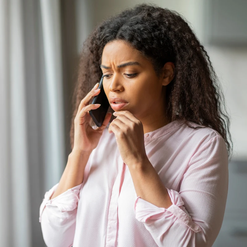 Concerned woman talking on a smartphone.